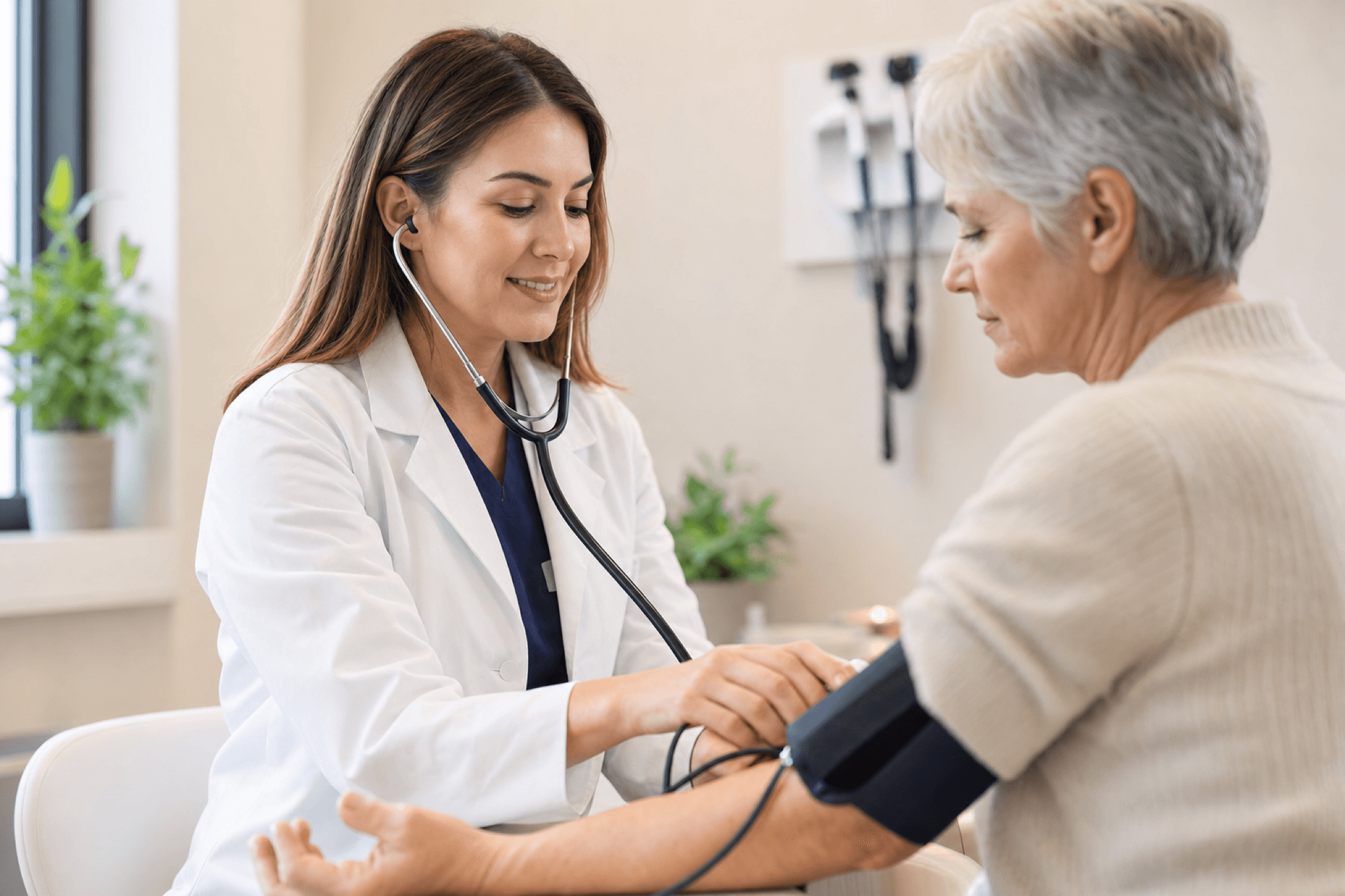 Provider taking a patient's blood pressure during an exam
